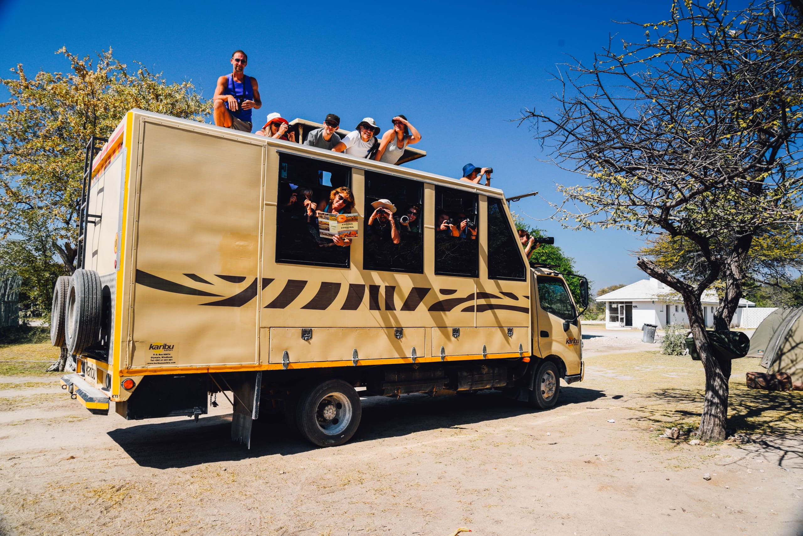 Pullman safari in Namibia con tuuristi intenti a osservare e fotografare il paesaggio esterno